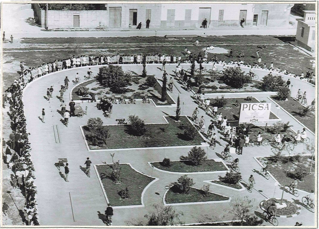 Dia 26 de febrer de 1965 es va inaugurar i fou beneït el Parc Infantil de Transit, ubicat a l’ample recinte exterior de l'Escola Graduada. A l'acte hi varen assistir les primeres autoritats locals, encapçalades per l'alcalde, Rafael Serra Company, l'alcalde de Palma, el cap de la Prefectura Provincial de Palma, l’alcalde d'Inca i tres caps de secció de la Prefectura Central de Trànsit, arribats expressament de Madrid. Va beneir el nou recinte l'ecònom parroquial, Jaime Vallés, i seguidament els nens assistents al primer curs d'educació viària varen oferir una exhibició davant tots els presents, incloses les càmeres de Televisió Espanyola, que van deixar testimoniatge d'un nou esdeveniment que va encuriosir la població. La direcció del parc va ser assumida pel mestre del “Grup Escolar General Primo de Rivera”, actual "Sa Graduada", Cristòfol Bennàssar. La crònica que donava compte del fet destacava la “gran brillantor que van revestir tots els actes, als quals es va sumar una considerable majoria d'habitants de la vila de sa Pobla”. La informació, igualment apuntava que la construcció del nou parc havia estat possible “gràcies al gest magnànim d'un ciutadà que va donar una important suma per a la seva creació”. L'import de la donació va ser de 50.000 pessetes (300 euros) i el ciutadà en qüestió, del qual no es va publicar el seu nom, va ser el conegut industrial electricista de la localitat, Francisco Gost Amer “Xesc Curro”, mort el 1968, una de les persones que a sa Pobla van patir molt de prop les repressions del règim franquista. Segons el fill del donant, el popular poeta local i activista cultural, Toni Gost Bennàssar “Curro”, la decisió presa pel seu pare va ser motivada per un accident de trànsit que va sofrir el seu pare amb un nen de la localitat, que sortia d'un camí rural per a entrar a la carretera d'Inca per la qual hi circulava Xesc Gost, sense que haguessin de lamentar-se importants lesions personals. Amb aquell acte solidari, Xesc Gost pretenia que ja, des de nens, els més joves habitants del poble coneguessin les normes de circulació, encara que anessin conduint una bicicleta. El Parc Infantil de Trànsit de sa Pobla va ser un dels pioners de les illes i es va aixecar en els terrenys de propietat municipal, situats darrere del pati del centre escolar Sa Graduada, entre els carrers Miquel Verdera i Traginers, terreny que, en els anys 30, fora escenari dels partits de futbol que disputaven “Marjalers contra Menestrals” i que l'any 1935, va ser el primer camp de la recentment fundada “Unió Sportiva Poblense”. Les primeres classes d'educació viària les impartia el mestre d'escola Llorenç Crespí i després ho van fer membres de la, llavors, Policia Municipal: Tolo Alomar, Xisco Company, Tomeu Mir, Tomeu Socias. Primer es feien les pràctiques amb bicicleta, després amb karts de pedals, fins que van arribar els de motor “de la marca Peugeot, que aviat van deixar de funcionar”, segons comenta un dels citats monitors. Campionat nacional El mes de maig de 1975, el Parc Infantil de Trànsit de sa Pobla va ser l'escenari dels exercicis pràctics del XI Campionat d'Espanya de Parcs Infantils de Trànsit, celebrat a Balears. L'elecció l'havia exposat, un any abans, el que durant una llarga etapa va estar al capdavant de la direcció de la Prefectura provincial de trànsit de Balears, Tomás Sastre, a l'alcalde de sa Pobla, Rafel Serra Company “Tianet”, qui en principi es va mostrar un poc reticent al·legant dificultats pressupostàries, així com de personal i mitjans que suposaria la responsabilitat d'acollir un esdeveniment de tals dimensions. Serra, al final va accedir davant les reiterades insistències del senyor Sastre i d'Alexandre Ballester, llavors relacions públiques i responsable de protocol de l'Ajuntament, al qual li va ser encomanada la tasca organitzativa. Tots els detalls van ser extremadament cuidats perquè l'organització de l'esdeveniment de talla nacional fos -com ho va ser- tot un èxit. Ballester, en coordinació amb Antoni Femenías, del cos tècnic de Trànsit, i els policies de l'Ajuntament de Palma, Salvador Torreta i Antonio Borrás, van desplegar el seu enginy per a cuidar tots els detalls. Des de la construcció d'una llotja d'autoritats, degudament engalanada amb els colors de la bandera nacional, instal·lació de megafonia i línia telefònica, fins a les atencions de quatre joves hostesses degudament uniformades. Els 180 participants al campionat nacional van arribar al poble a les cinc de la tarda del 2 de maig, després d'haver realitzat, al matí, les proves teòriques en el col·legi d'Ensenyament Mitjà Verge de Sant Salvador de Felanitx. Rebuts per les autoritats provincials i locals i diversos alts càrrecs de la Direcció General de Trànsit, els equips i els seus respectius monitors van desfilar als compassos de la banda de cornetes i tambors de la confraria de Sant Antoni, davant tots els nens i nenes dels diferents centres escolars de la localitat i els nombrosos veïns que no van voler perdre's el brillant espectacle. La jove atleta local, Polita Gost, que feia poc havia conquistat un títol provincial, va ser la portadora de la torxa que va encendre el pebeter aixecat per a l'ocasió. Després d'unes paraules de salutació i benvinguda de l'alcalde Serra, van donar inici les proves de circulació en “karts”, que van continuar al matí de l'endemà dissabte. A la tarda es van desenvolupar a Palma les proves d'habilitat ciclista. Sa Pobla equip campió L'expectació i brillantor de les jornades de l'esdeveniment es van veure coronades per l'èxit aconseguit pels participants de l'equip local, que es va proclamar vencedor absolut, seguit de Madrid, Elx, Lleó i Albacete. L'equip pobler que preparava el monitor, mestre d'escola, Llorenç Crespí “Morber”, ajudat per Miquel Marroig, estava integrat pels nens d'entre 13 i 14 anys: Miquel Bonnín Quetglas, Rafel Català Pastor, Miquel Bonnín Pérez i Joan Barceló Mateu. Els resultats van ser fets públics una vegada finalitzades les proves d'habilitat ciclista celebrades en una abarrotada Plaza Obispo Berenguer de Palou, de Palma, la tarda del 3 de maig. Va fer lliurament dels premis i trofeus el director general de trànsit, Muñoz Repiso. A sa Pobla es va rebre la notícia de l'èxit del seu equip amb enorme satisfacció. Sa Pobla havia triomfat en l'organització i en la competició en aquella onzena edició del Campionat d'Espanya de Parcs Infantils de Trànsit. El premi va ser de 100.000 pessetes, que es van destinar a l'adquisició de karts i a la realització de millores al parc. Diferents equips de sa Pobla, van participar en distints campionats nacionals, celebrats a ciutats com Barcelona, Madrid, Gijón, Sevilla o Elx, en els últims anys de la dècada dels seixanta i principis dels setanta, amb notables èxits. Posats en contacte amb el policia tutor, Damià Ribot, ens informa que les classes pràctiques es varen suspendre el temps de la pandèmia i que actualment només s'imparteixen, als centres escolars, classes teòriques. L'espai que ocupa el Parc Infantil de Trànsit es destina a pati per als alumnes del centre escolar Sa Graduada.