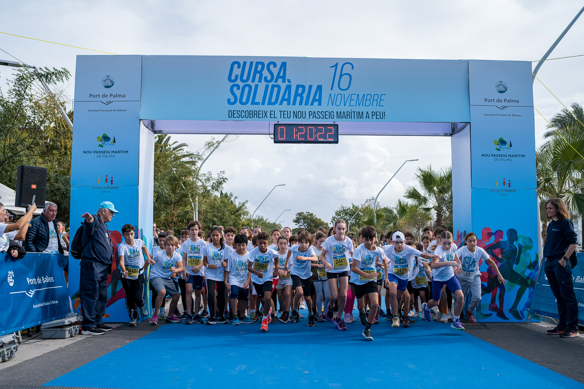 El Nou Passeig Marítim de Palma s’ha estrenat aquest cap de setmana amb una resposta massiva de la ciutadania. La primera Cursa Solidària organitzada per l’Autoritat Portuària de Balears (APB) ha reunit més de 2.100 participants entre totes les modalitats, en un esdeveniment que ha combinat esport, oci familiar i suport social. La sortida de les proves s’ha fet aquest diumenge amb la presència de la presidenta del Govern, Marga Prohens; el batle de Palma, Jaime Martínez; el president de l’APB, Javier Sanz; el president de Projecte Home Balears, Jesús Mullor, i el director de l’APB, Toni Ginard. Sanz ha destacat l’alta participació i la voluntat de l’APB d’obrir el passeig a la ciutadania. “Hem entregat el passeig Marítim als ciutadans, com havíem promès, i amb un èxit impressionant de participació. Hem fet un passeig Marítim per a les persones, i ho hem celebrat amb una cursa solidària perquè la gent de totes les edats passegi”, ha expressat. Mullor, per la seva banda, ha agraït que Projecte Home hagi estat l’entitat beneficiària de la recaptació. Ha subratllat que la iniciativa “plega esport i solidaritat per a una causa necessària com és la rehabilitació i prevenció de joves en el tema de les addiccions”. Les activitats han inclòs sessions de ball i esport a l’aire lliure, una fira d’entitats vinculades a l’esport i la salut i una jornada de curses que ha començat amb la prova de 10 km, seguida de les curses infantils i de la caminada i cursa populars de 4 km. Els participants del recorregut llarg han pogut accedir excepcionalment als molls de Ponent, habitualment restringits al públic. En acabar la jornada, l’APB ha lliurat a Projecte Home Balears un xec de 10.538,40 euros, l’import íntegre de la recaptació. Resultats esportius En la cursa de 10 quilòmetres, Antoni Gran s’ha imposat en categoria masculina amb un temps de 32:15, seguit de Lluís Caldentey i José Luis Lobay. En la prova femenina, Leonor Font ha marcat el millor registre amb 36:08, per davant de Francisca De Villalonga i María José Medina. En el recorregut de 4 quilòmetres, el guanyador masculí ha estat Yoel Bastida (13:42), seguit per Pau Garcia i Pedro Olmo. En categoria femenina, Carolina Routier ha estat la més ràpida amb 16:12, mentre que Lucia Monte i Sandra Moreno han completat el podi. La jornada també ha reconegut els grups més nombrosos, una categoria per incentivar la participació de centres educatius i clubs. Les escoles Verge del Carme i Montesión, i el club Malif Mallorca Trail han rebut xecs per valor de 500, 300 i 200 euros en material esportiu. La nina Martina Ramis ha estat l’encarregada de tallar la cinta que ha donat inici a la cursa popular, en què molta gent ha pogut trepitjar per primera vegada el nou espai urbanístic. Un passeig renovat La cursa ha servit per mostrar al públic el resultat de la reforma integral del passeig marítim, un projecte executat per l’APB amb una inversió superior als 50 milions d’euros i que ha transformat 3,5 quilòmetres de façana marítima. El nou espai prioritza vianants i ciclistes, amplia zones verdes i incorpora criteris de mobilitat sostenible. Durant els tres anys d’obres s’han plantat més de 2.300 arbres, creat 37.000 m² de zones enjardinades i habilitat àmplies àrees de pas i lleure. També s’han instal·lat sistemes de drenatge sostenible, enllumenat LED intel·ligent i punts de recàrrega per a vehicles elèctrics.