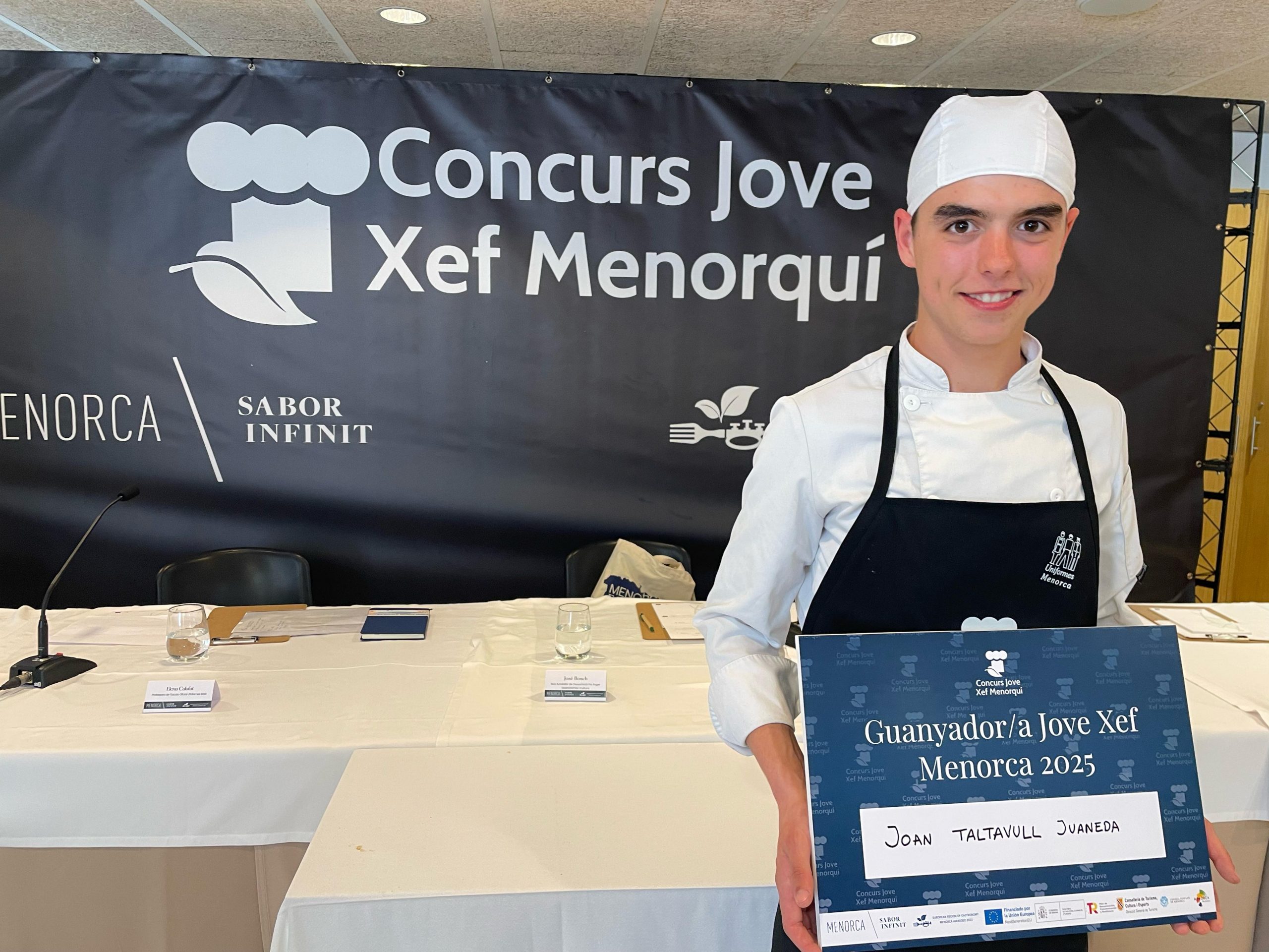 El cuiner ciutadellenc Joan Taltavull, guanyador del concurs Jove Xef Menorquí 2025, afronta els darrers dies de preparació abans de participar al European Young Chef Award, que tindrà lloc a Catalunya del 24 al 28 de novembre. El jove talent competirà amb una interpretació més suau i personal del tradicional arròs de la terra, amb la qual espera captivar el jurat internacional del certamen organitzat per l’IGCAT. La competició se celebrarà a l'Escola Universitària d’Hoteleria i Turisme de Sant Pol de Mar, a Barcelona. Taltavull hi arriba després de mesos d’entrenament intens amb els seus mentors, els cuiners Sílvia Anglada i Toni Tarragó, del restaurant Es Tast de na Sílvia. El procés, explica, ha estat tan enriquidor com exigent, especialment per la seva recent mudança a Barcelona, que l’ha obligat a compaginar els estudis amb viatges constants a Menorca per perfilar el plat. Tot i mantenir el secret propi de qualsevol competició, el jove xef avança que la seva proposta és una versió diferent del popular plat menorquí i agraeix també el suport lingüístic del seu professor d’anglès, Hendrick, de l’Escola d’Adults de Menorca, que col·labora amb Menorca Regió Europea de Gastronomia. Taltavull confessa que viure aquesta experiència “és increïble” i que representar Menorca en un escenari gastronòmic europeu és “el somni de qualsevol estudiant de cuina”. Entre els seus referents cita cuiners com Joan Bagur, Paula Florit, Felip Llufriu, Joan Capó i el talent emergent de Pau Sintes, a més dels seus mentors. El cuiner menorquí segueix així la senda marcada per altres participants de l’illa: pren el relleu d’Oscar Roca, que el 2024 va competir a Sicília, i aspira a repetir fites com la victòria de Pau Sintes el 2022 o el segon lloc de Cristina Pons el 2023.