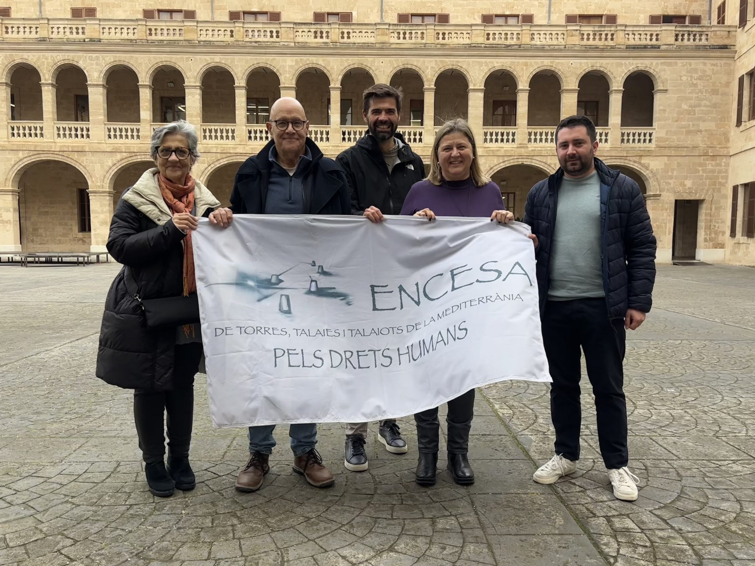 Avui, 31 de gener de 2026, encenem de nou les torres, les talaies i els talaiots que guaiten la nostra mar comuna. Monuments del nostre patrimoni cultural que, per unes hores, esdevenen fars de memòria, dignitat i esperança. Amb cada bengala, afirmam que la Mediterrània ha de ser espai de vida i no de mort; pont d’humanitat, i no frontera de dolor. Som aquí perquè creim que cap persona és il·legal. Som aquí perquè sabem que la por i l’odi no poden governar la mar ni els nostres cors. Encendre és la nostra manera de mostrar-nos a favor de la vida, de la justícia, de l’acollida. El fum i la llum que avui s’alcen no són un espectacle: són un compromís col·lectiu que ens recorda que cada trajecte, cada cos, cada història mereix ser protegit. Aquest acte és una abraçada que travessa municipis, illes i ribes. És una crida a totes les veus que rebutgen la indiferència. No hi ha d’haver distància entre qui mira des d’una talaia i qui navega cercant refugi; la mateixa humanitat ens sosté. Si encenem és perquè no volem resignar-nos a la fredor de les xifres davant l’agonia dels relats que redueixen les persones a estadístiques. Per açò, avui aixecam una llum de protesta i també d’esperança. La Mediterrània és bressol de cultures, llengües i camins compartits. Ho ha estat sempre. I més enllà, l’Atlàntic és també espai de trobada, travessies i anhels. No podem permetre que cap mar es converteixi en cementeri invisible o en trinxera d’odi. No podem acceptar que es jutgi qui rescata, qui acompanya, qui dona menjar, qui estén la seva mà. Tota acció solidària és un acte de decència, d’humanitat. Avui, encendre és fer memòria. Memòria de qui no hi és. Memòria de les mans que han rescatat, cuinat, acollit, acompanyat. Memòria de les places que s’han omplert per exigir dignitat. Avui, encendre també és fer futur. Un futur en què el Mediterrani torni a ser casa compartida, on la diferència no fa por i s’encén la flama de l’acollida. Un futur en què cadascú de nosaltres es miri la mar i hi vegi possibilitat de convivència, no de frontera. Avui, quan el fum s’alci i la llum s’estengui, guardem silenci un instant. Pensem en els noms que no coneixem, en les abraçades que no han arribat, en les il·lusions ofegades. I, tot seguit, trenquem el silenci amb el compromís de convertir aquesta encesa en una reivindicació quotidiana. QUE DES DE CADA TORRE, TALAIA I TALAIOT S’ESCAMPI UN MISSATGE ALT I CLAR: ELS DRETS HUMANS NO ES NEGOCIEN. NO SÓN UNA OPCIÓ NI UN PRIVILEGI. SÓN LA BASE DEL NOSTRE PACTE SOCIAL I DE LA NOSTRA DIGNITAT COL·LECTIVA. Si avui encenem és perquè ens resistim davant la injustícia. Perquè sabem que cada gest, per petit que sigui, suma. I perquè, la nostra unió ens enforteix en la defensa d’una humanitat compartida i la igualtat de tracte per a tothom, vingui d’on vingui. Continuarem encenent, continuarem oferint llum. Per una mar plena de vida, d’acollida i de drets. Que la llum d’avui sigui espurna de futur. I que, quan la mar torni a estar fosca, ens recordi que tenim el deure d’encendre-la, juntes i junts.
