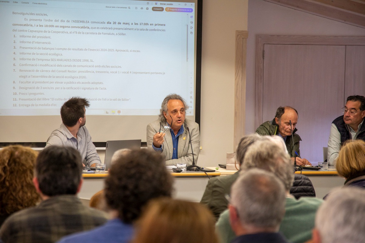 El president de la Cooperativa Agrícola Sant Bartomeu de Sóller, Miquel Gual, continuarà quatre anys més al capdavant de l’entitat després de ser reelegit en el marc de l’assemblea general. Amb aquesta renovació, Gual encadena el seu quart mandat des que assumí la presidència l’any 2014, consolidant una etapa de continuïtat en la direcció de la institució agrària sollerica. La seva figura ha guanyat pes dins el sector en els darrers anys. A més de presidir també la Cooperativa del Camp Mallorquí, recentment ha estat notícia per l’adquisició de la finca de Font des Teix, un moviment que reforça la seva vinculació directa amb el territori i l’activitat agrària. La renovació parcial de la junta directiva ha introduït canvis en l’equip gestor. Xavier Paredes s’incorpora com a vocal primer, mentre que Miquel Estarellas assumirà les funcions de tresorer, en una aposta per reforçar l’estructura interna de la cooperativa. Un exercici marcat per la davallada de la collita Durant l’assemblea, Gual va exposar el balanç econòmic de l’últim exercici, que s’ha tancat amb unes pèrdues de 15.000 euros. El president va atribuir aquests resultats principalment a la mala campanya de l’oliva, que ha tingut un impacte directe tant en la producció d’oli com en la comercialització del producte. A aquesta circumstància s’hi ha sumat una reducció de l’estoc de confitures, fet que també ha incidit en la facturació global. Aquesta combinació de factors ha provocat una davallada d’ingressos que s’ha reflectit en els comptes anuals. Amb tot, Gual va voler rebaixar la preocupació dels socis recordant que l’any anterior la cooperativa havia tancat amb uns beneficis de 60.000 euros, evidenciant així la volatilitat pròpia del sector agrari. El repte de vendre més i millor De cara al nou mandat, la prioritat fixada per la presidència passa per reforçar la comercialització dels productes agraris. Gual ho va resumir amb una idea clara: augmentar les vendes per garantir una millor remuneració als productors. En aquest sentit, va assegurar que la cooperativa disposa dels recursos tècnics i humans necessaris per avançar en aquesta direcció. L’entitat arriba a aquesta nova etapa després d’haver fet diverses inversions rellevants. Entre aquestes, destaca la posada en marxa d’una tercera línia de producció d’oli orientada específicament al segment ecològic, l’adquisició d’una nova màquina calibradora de fruita i la incorporació com a soci a la fàbrica de confitures que fins fa poc gestionava el taller ocupacional Este Nou. Reconeixement a l’olivar de muntanya L’assemblea es va cloure amb un component cultural i de reconeixement al patrimoni agrari. Es va presentar el llibre “El cultiu de l’olivera i la producció de l’oli a la vall de Sóller”, coordinat per l’historiador Antoni Quetglas, una obra que posa en valor la tradició olivarera de la vall. Així mateix, la cooperativa va fer entrega de la seva medalla d’or a la finca Son Moragues, de Valldemossa, en reconeixement a la seva tasca de recuperació de l’olivar de muntanya i per la seva aposta decidida per la producció d’oli d’oliva ecològic, en un context on la sostenibilitat i la qualitat guanyen protagonisme dins el sector.